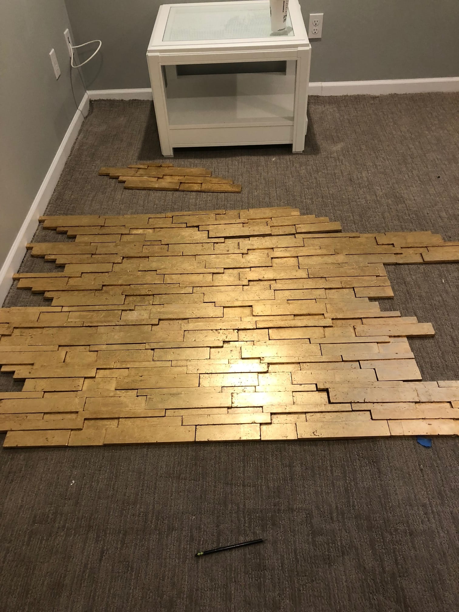 Gold stacked-stone tile panels laid out on the floor before installation