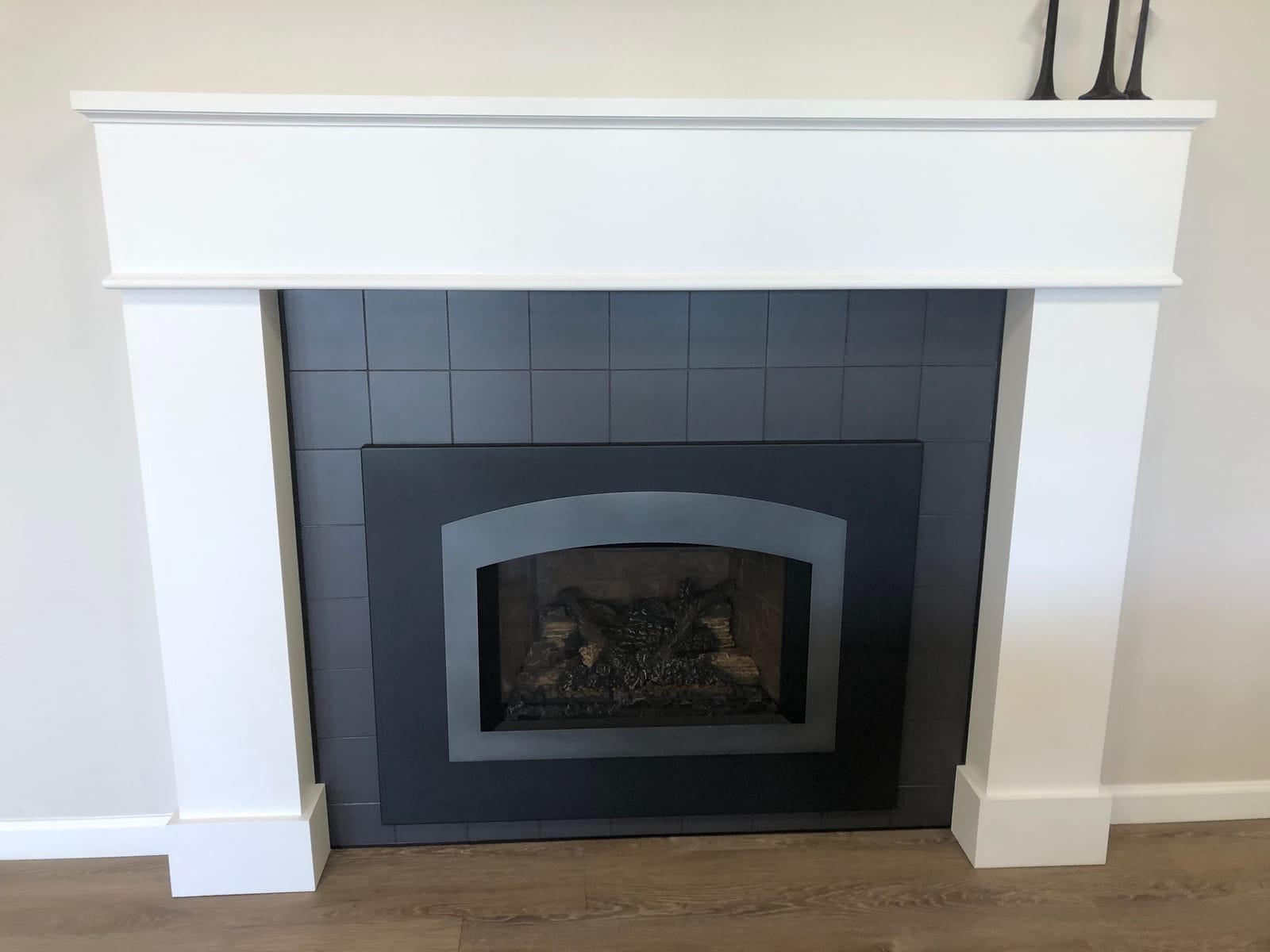 Gas fireplace with black tile surround and white mantel