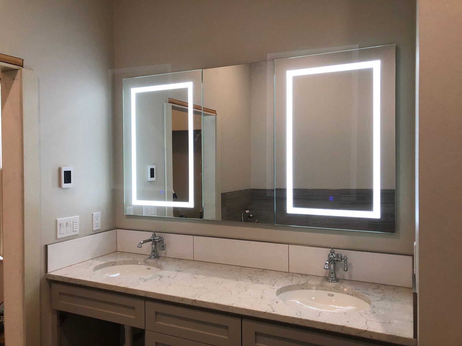 Double vanity with quartz countertop and lighted mirrors