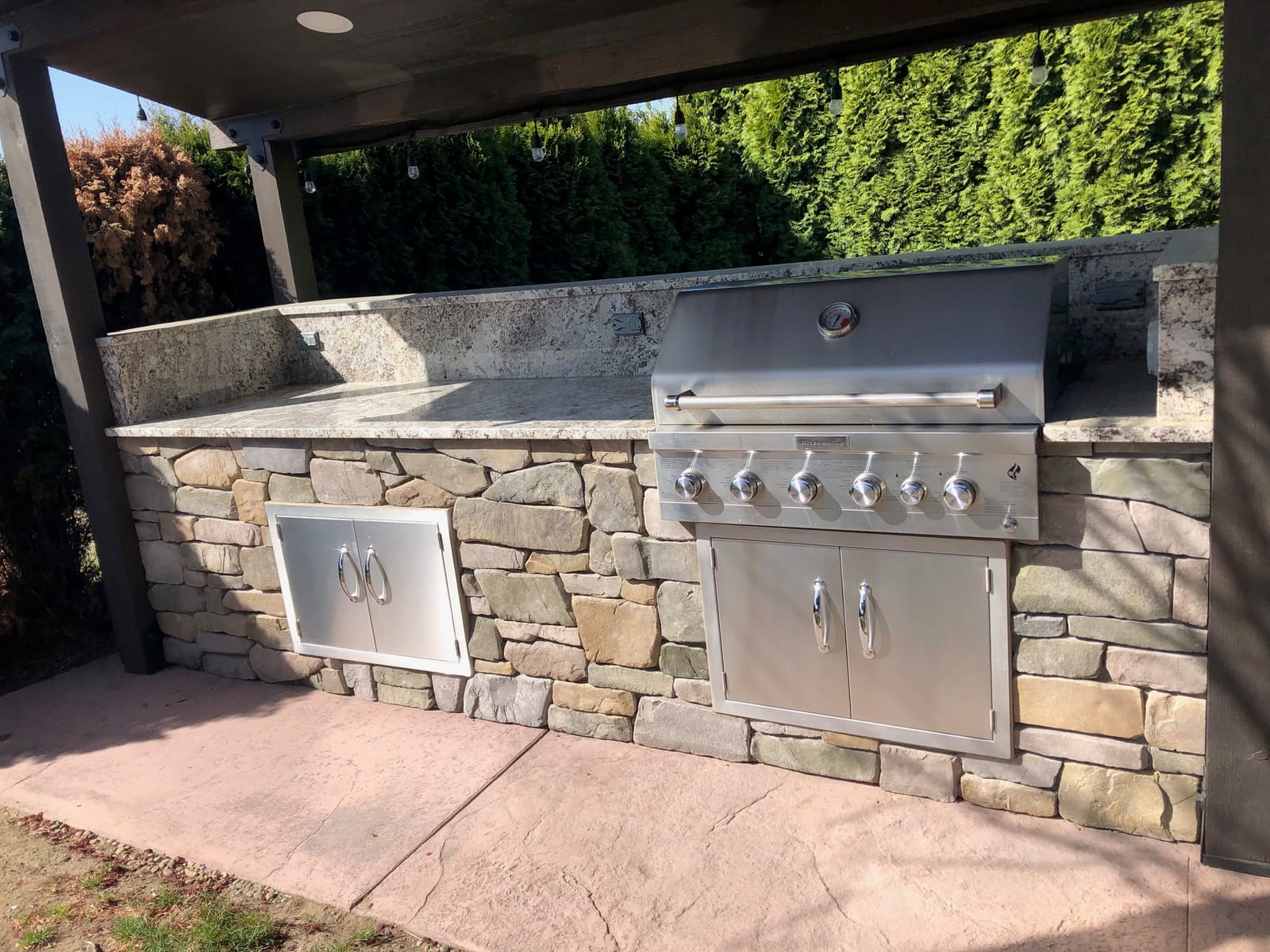 Outdoor kitchen with built-in stainless grill and access doors installed
