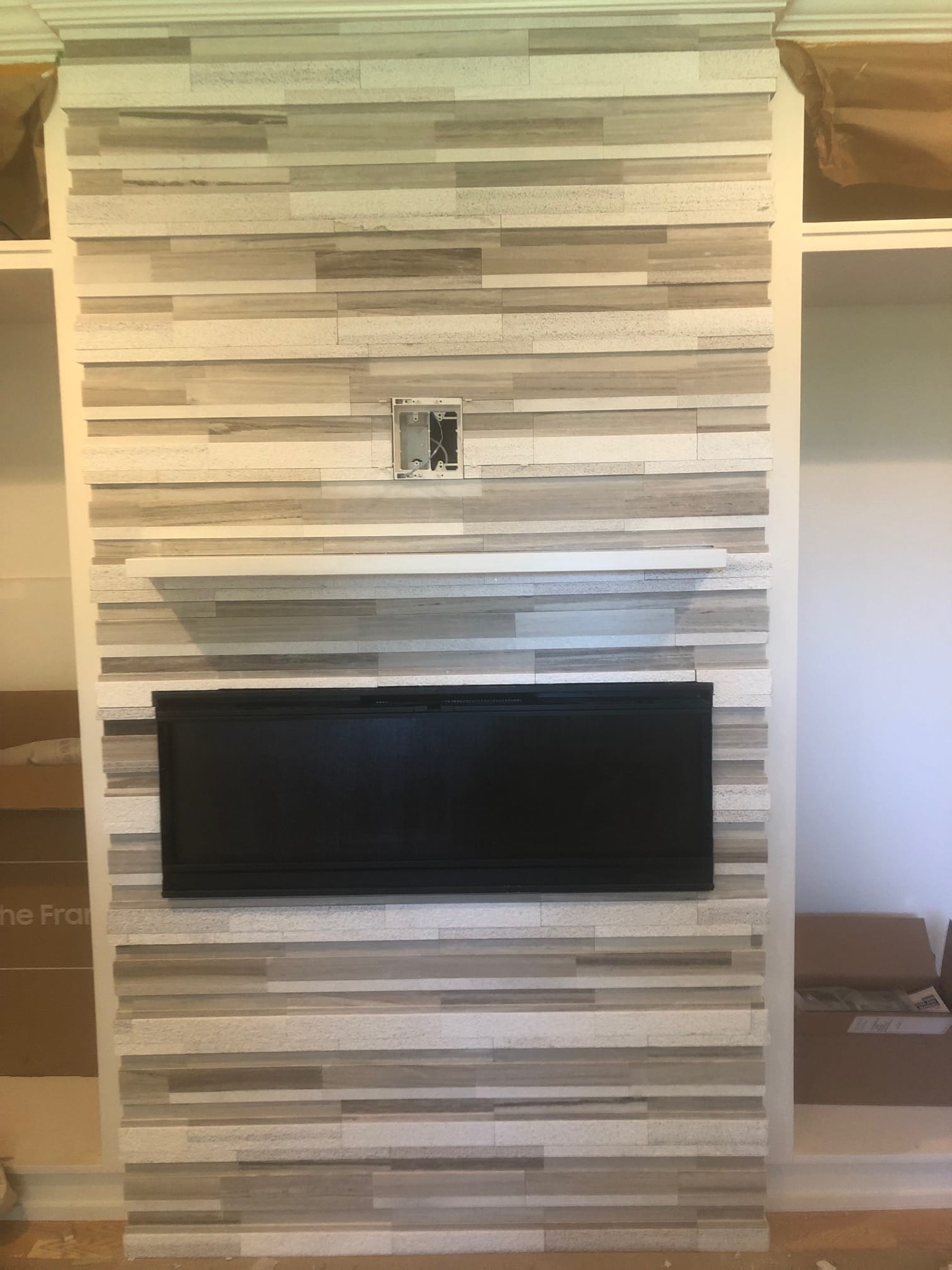 Linear fireplace set in a light stone feature wall with floating mantel