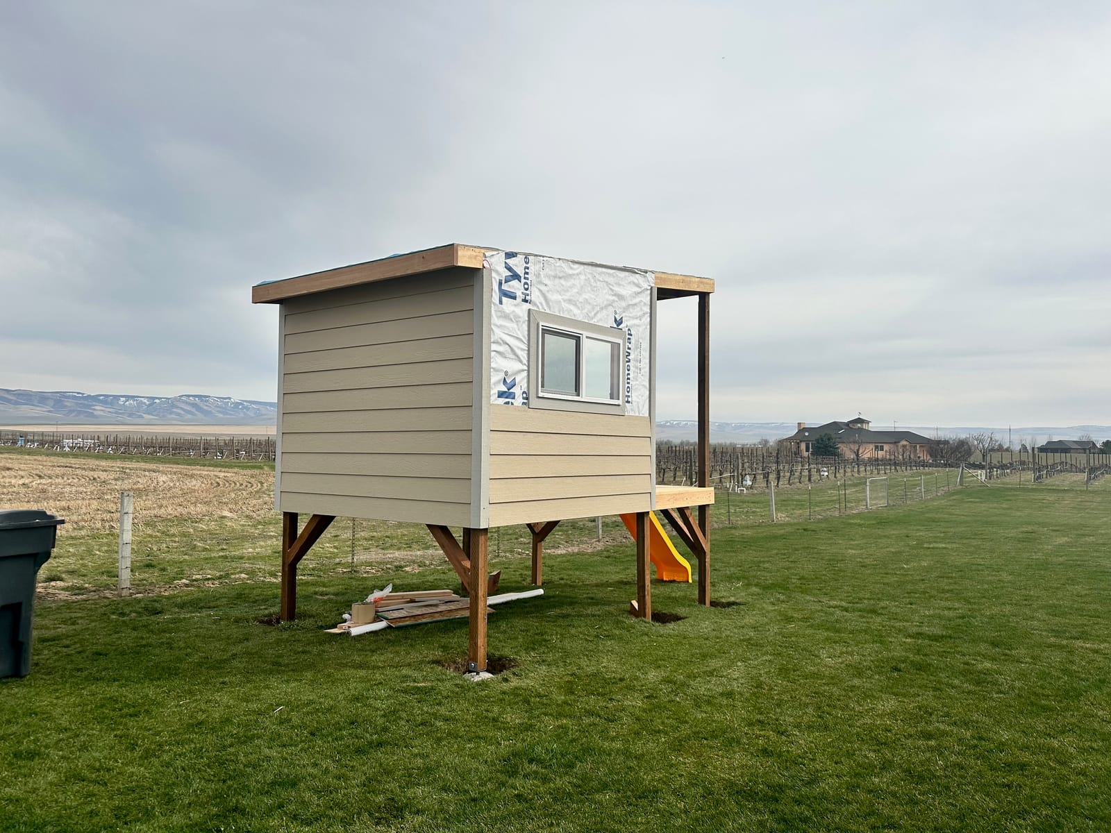 Elevated playhouse framed with house wrap and first siding