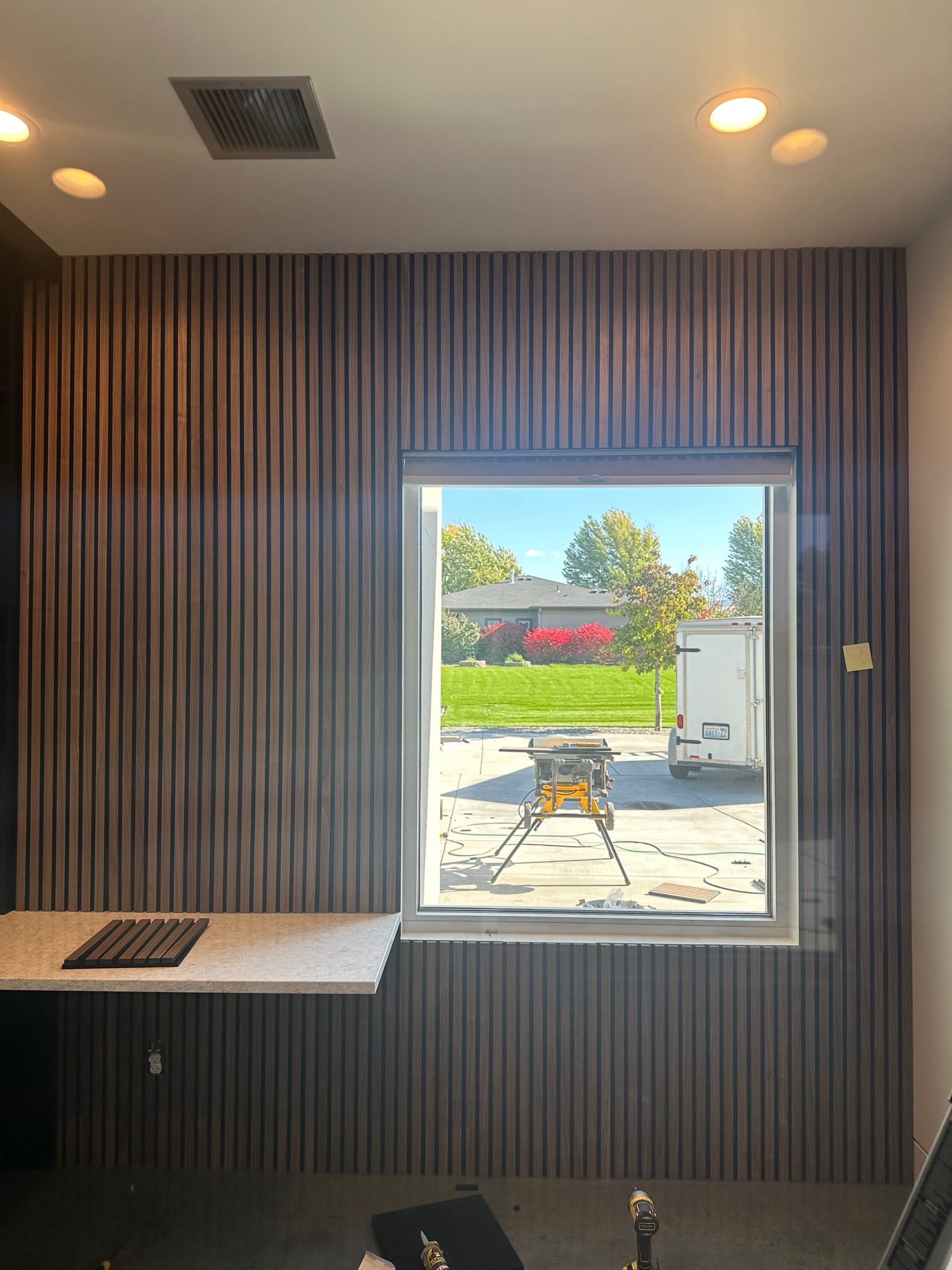 Wood slat accent wall with floating counter in a remodeled room