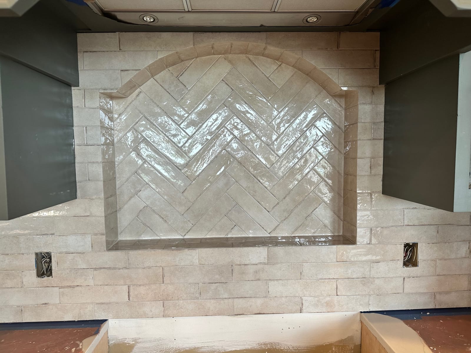 Arched niche finished in herringbone tile