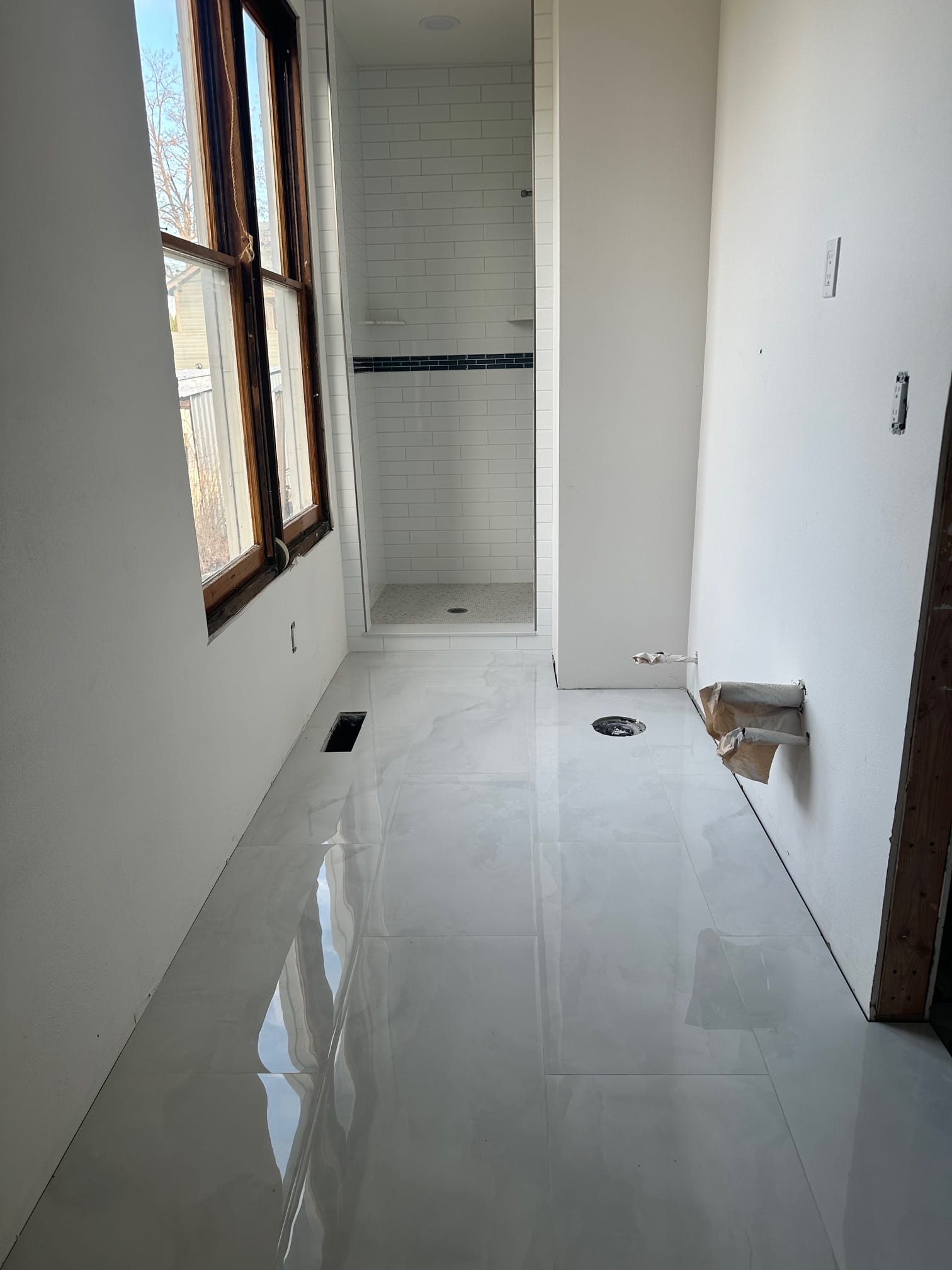 Finished bathroom with polished tile floor and subway-tile shower