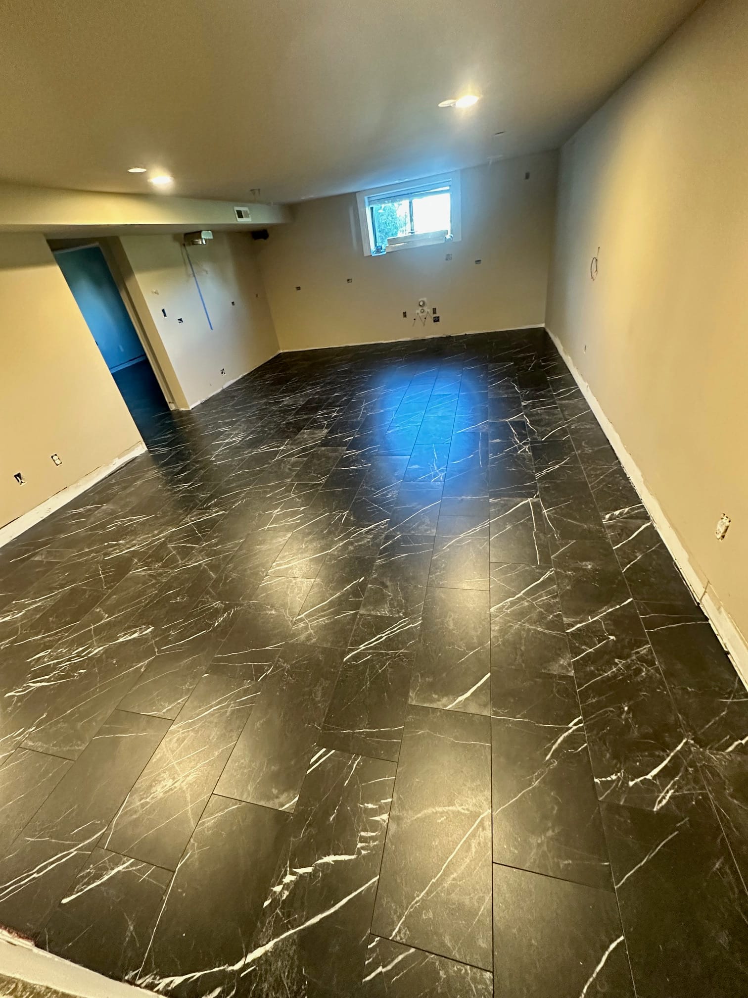 Renovated basement with marble-look tile flooring