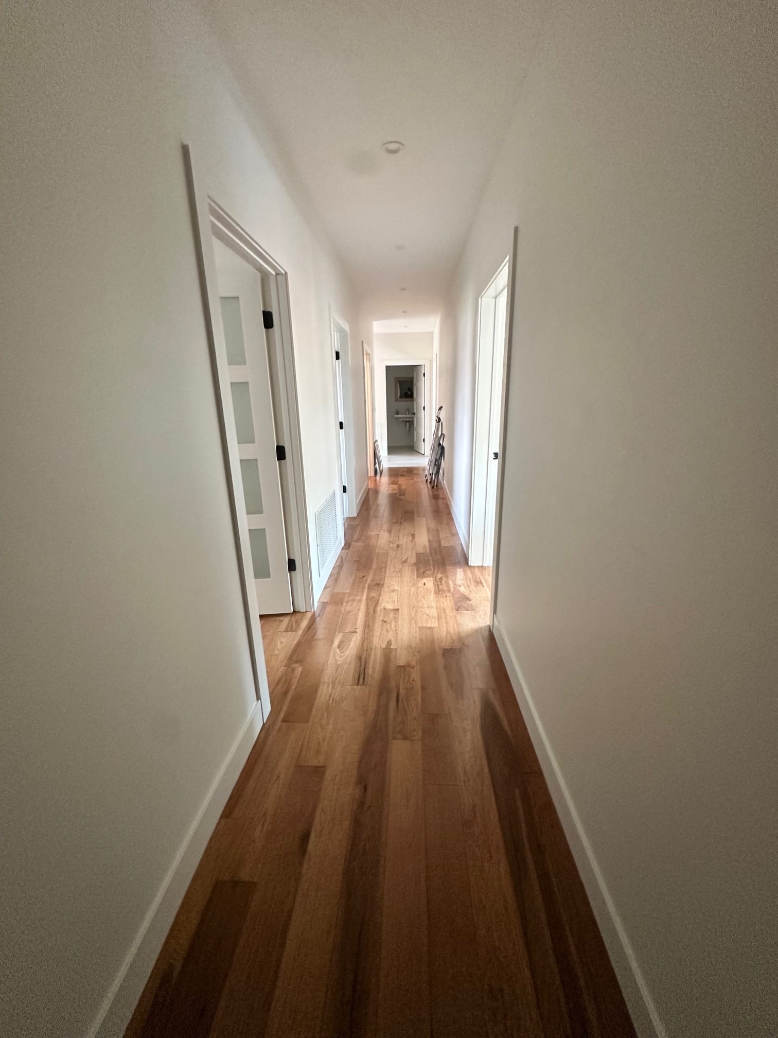 Finished hallway with hardwood floors and new doors and trim