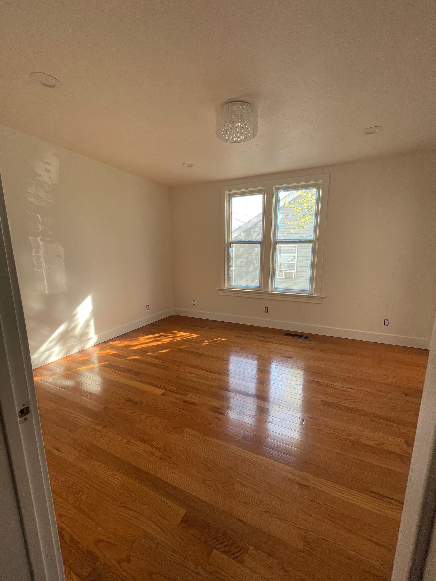 Remodeled room with refinished hardwood floor and fresh paint